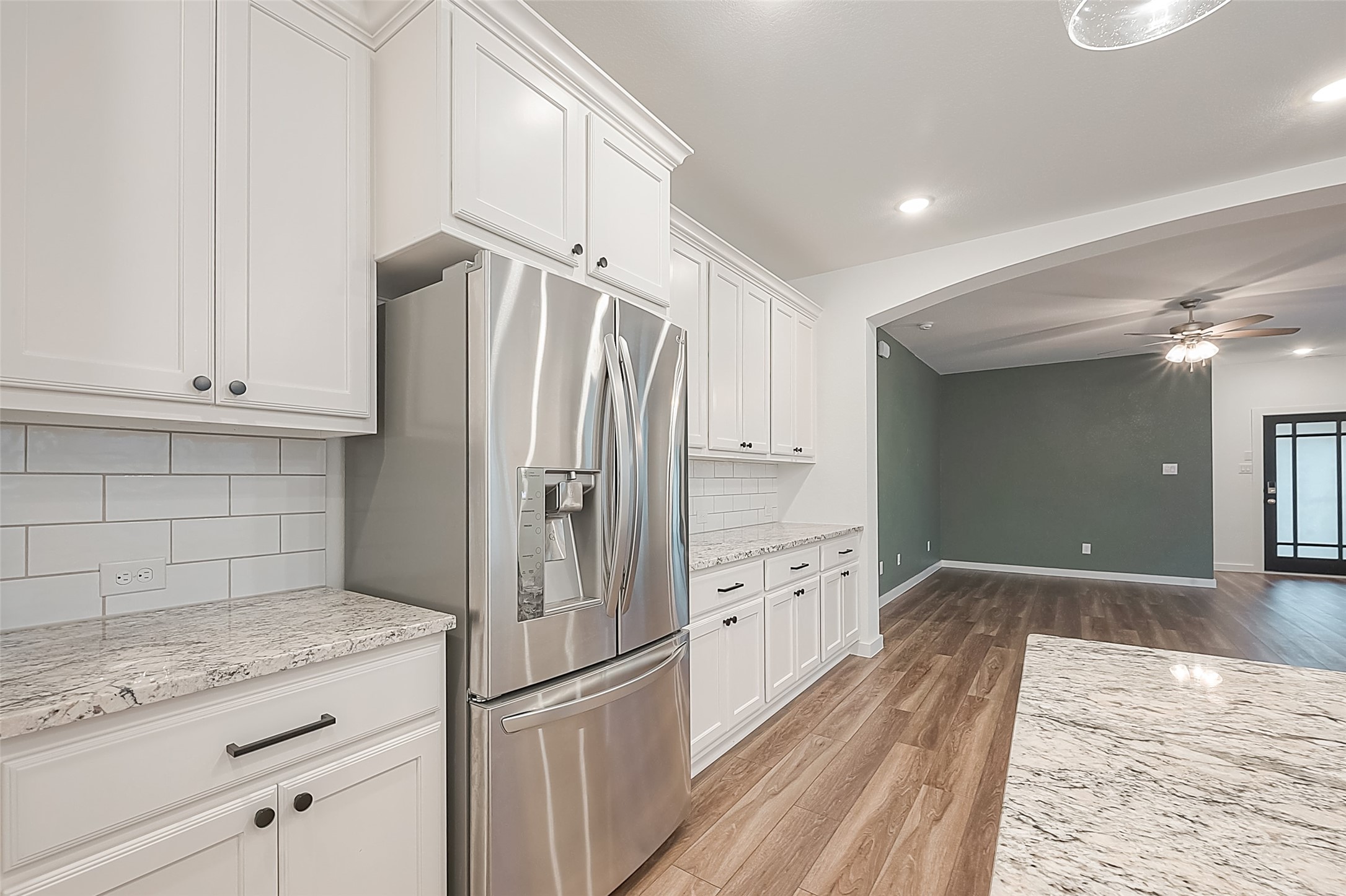 516 Timber Voyage Court Conroe, TX 77304 - Photo 10 of 25 a kitchen with granite countertop a refrigerator and cabinets