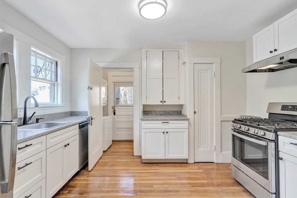 18-20 Walcott Road Watertown, MA 02472 - Photo 14 of 40 a kitchen with stainless steel appliances granite countertop a stove a sink and a refrigerator