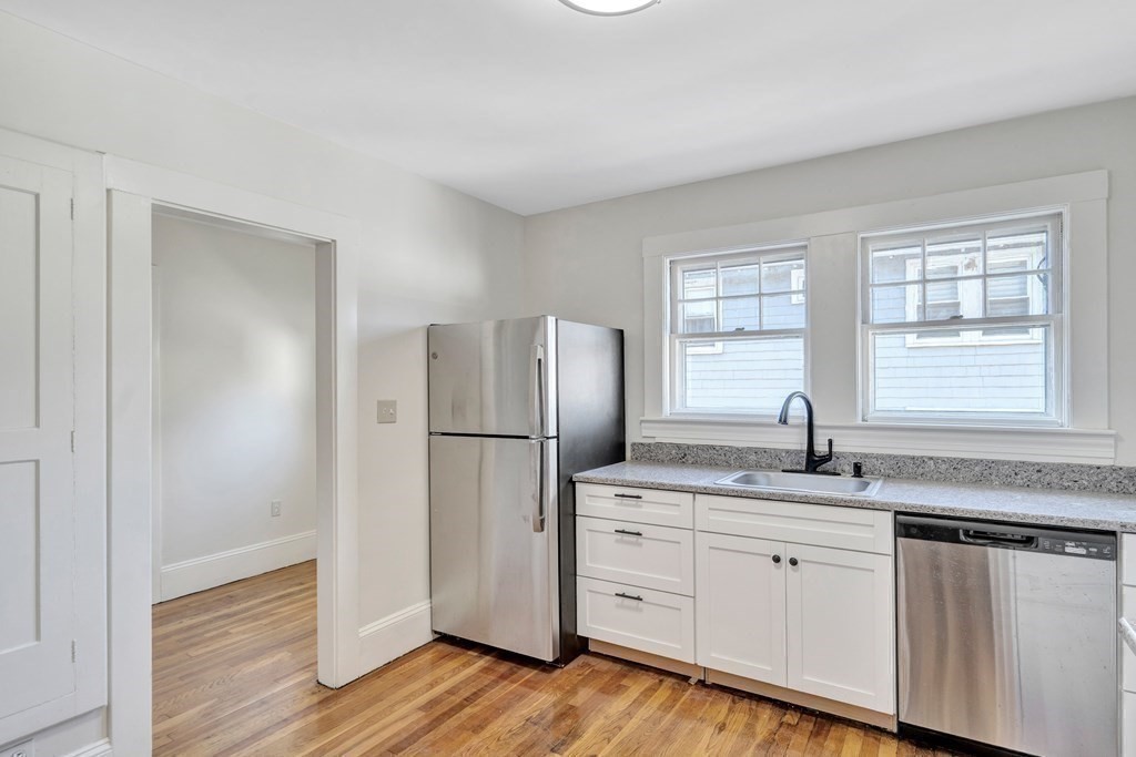 18-20 Walcott Road Watertown, MA 02472 - Photo 15 of 40 a kitchen with a refrigerator a sink and wooden floor