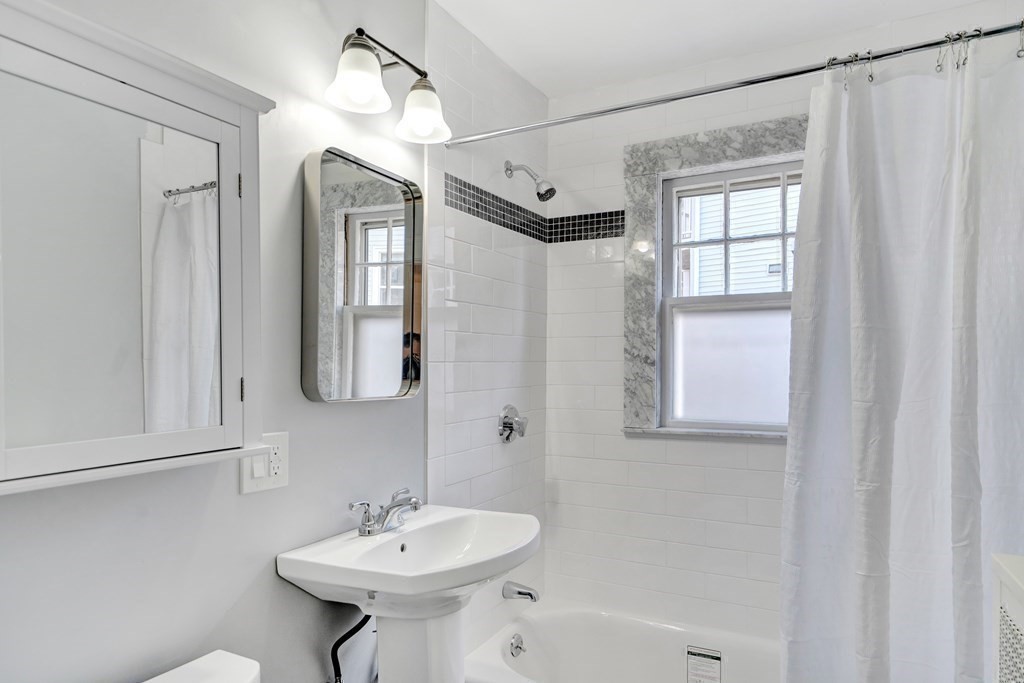 18-20 Walcott Road Watertown, MA 02472 - Photo 17 of 40 a bathroom with a sink a mirror and a shower