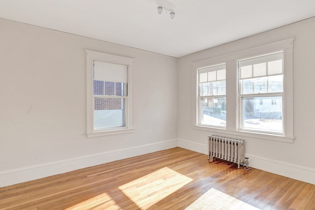 18-20 Walcott Road Watertown, MA 02472 - Photo 22 of 40 an empty room with wooden floor and windows