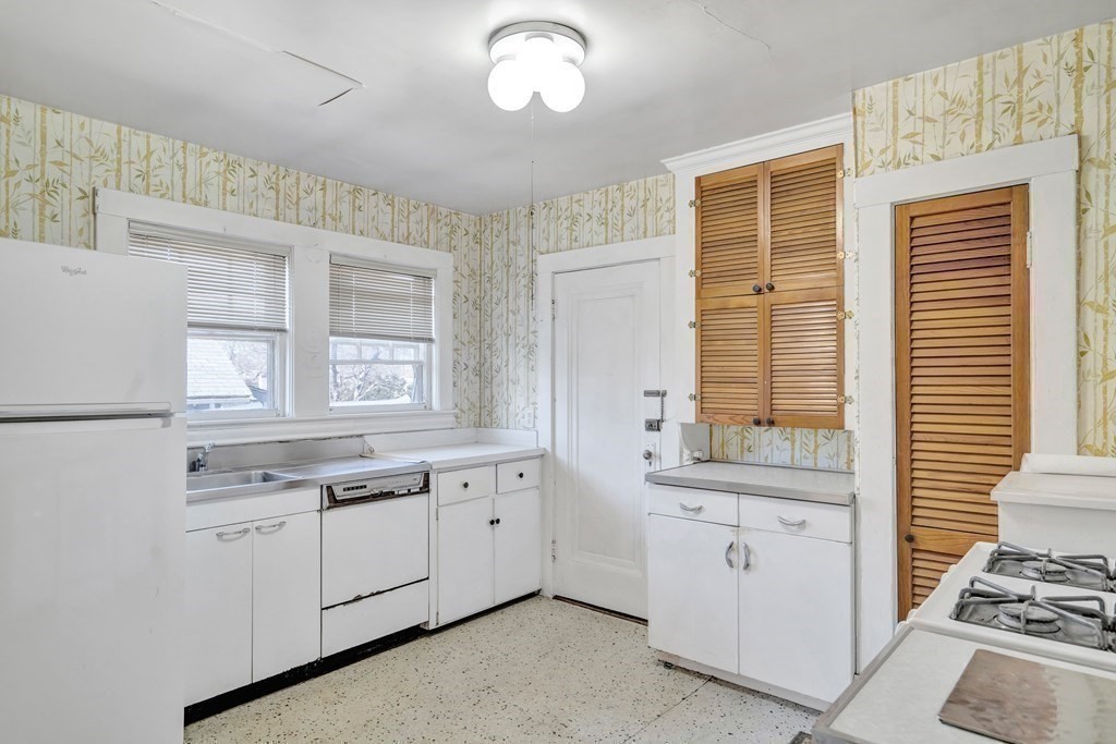 18-20 Walcott Road Watertown, MA 02472 - Photo 28 of 40 a kitchen with white cabinets and appliances