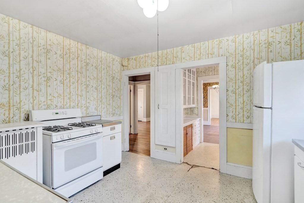 18-20 Walcott Road Watertown, MA 02472 - Photo 29 of 40 a kitchen with stainless steel appliances a stove a refrigerator and cabinets