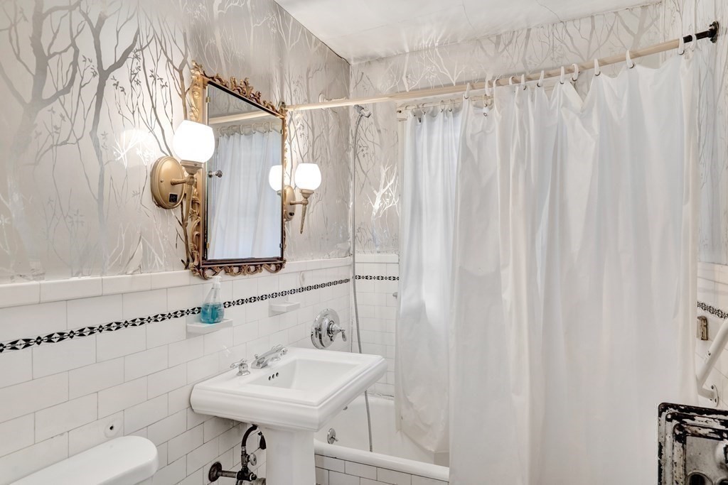 18-20 Walcott Road Watertown, MA 02472 - Photo 30 of 40 a bathroom with a sink a toilet and shower curtain