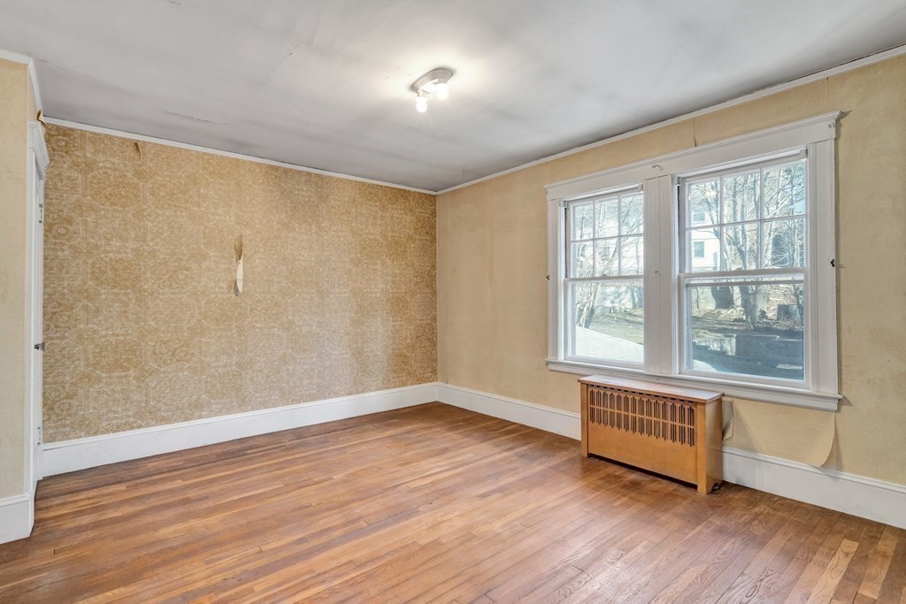 18-20 Walcott Road Watertown, MA 02472 - Photo 31 of 40 a view of an empty room with wooden floor and a window