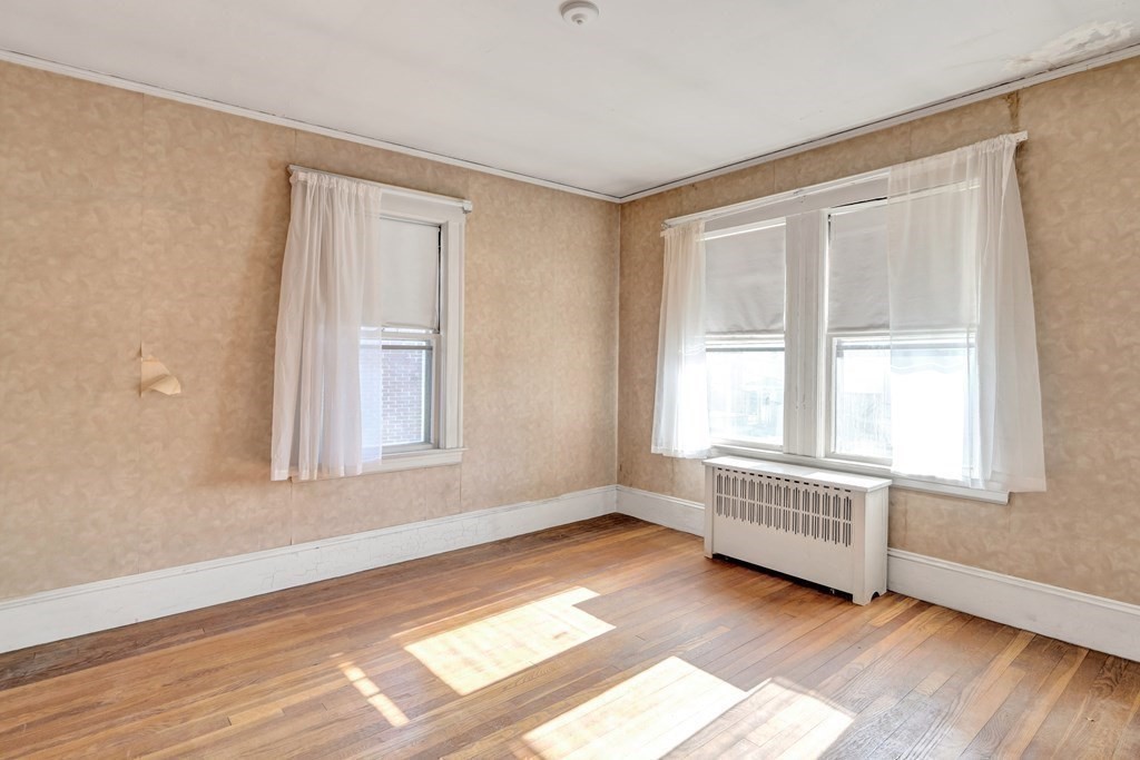 18-20 Walcott Road Watertown, MA 02472 - Photo 33 of 40 a view of an empty room with wooden floor and a window