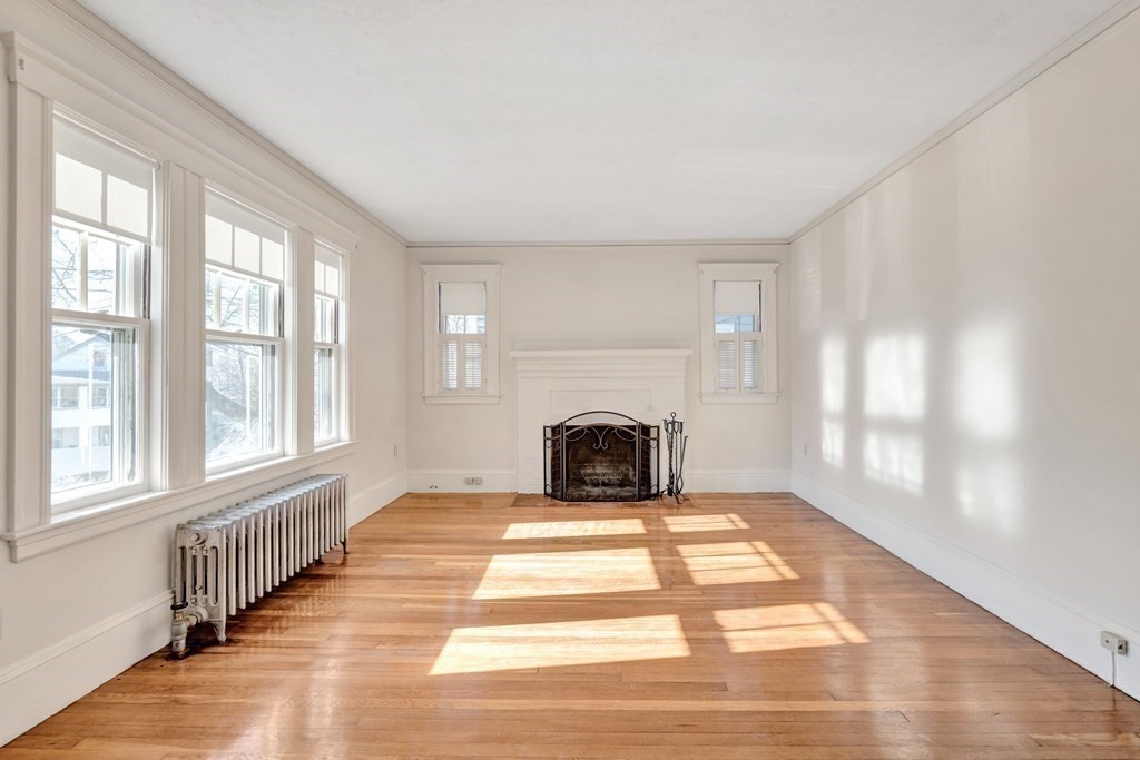 18-20 Walcott Road Watertown, MA 02472 - Photo 6 of 40 a view of an empty room with a fireplace and windows