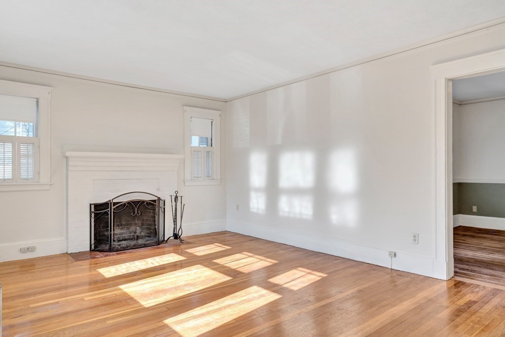 18-20 Walcott Road Watertown, MA 02472 - Photo 8 of 40 a view of empty room with wooden floor and fireplace