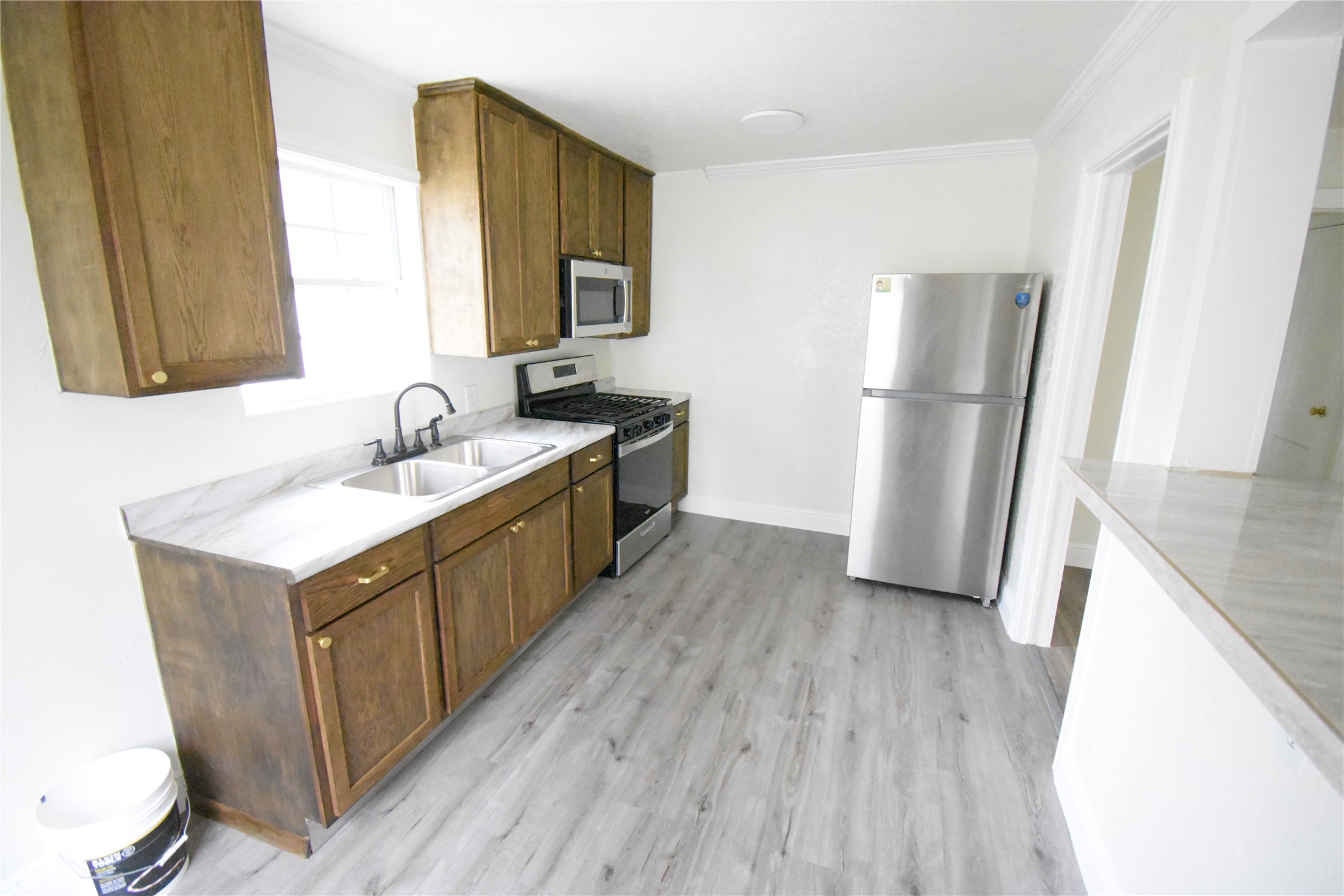 6229 Clover Ridge Street Houston, TX 77087 - Photo 16 of 25 a kitchen with a sink a refrigerator a microwave a sink and cabinets
