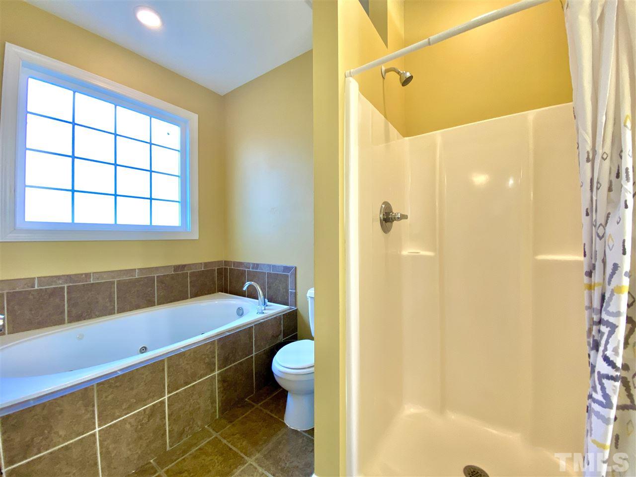 2513 Friendly Trail Raleigh, NC 27610 - Photo 16 of 29 a bathroom with a sink and a shower