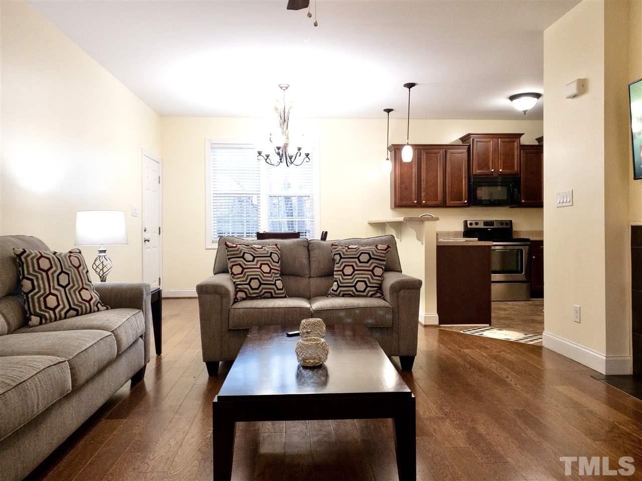 2513 Friendly Trail Raleigh, NC 27610 - Photo 6 of 29 a living room with furniture a flat screen tv and kitchen view