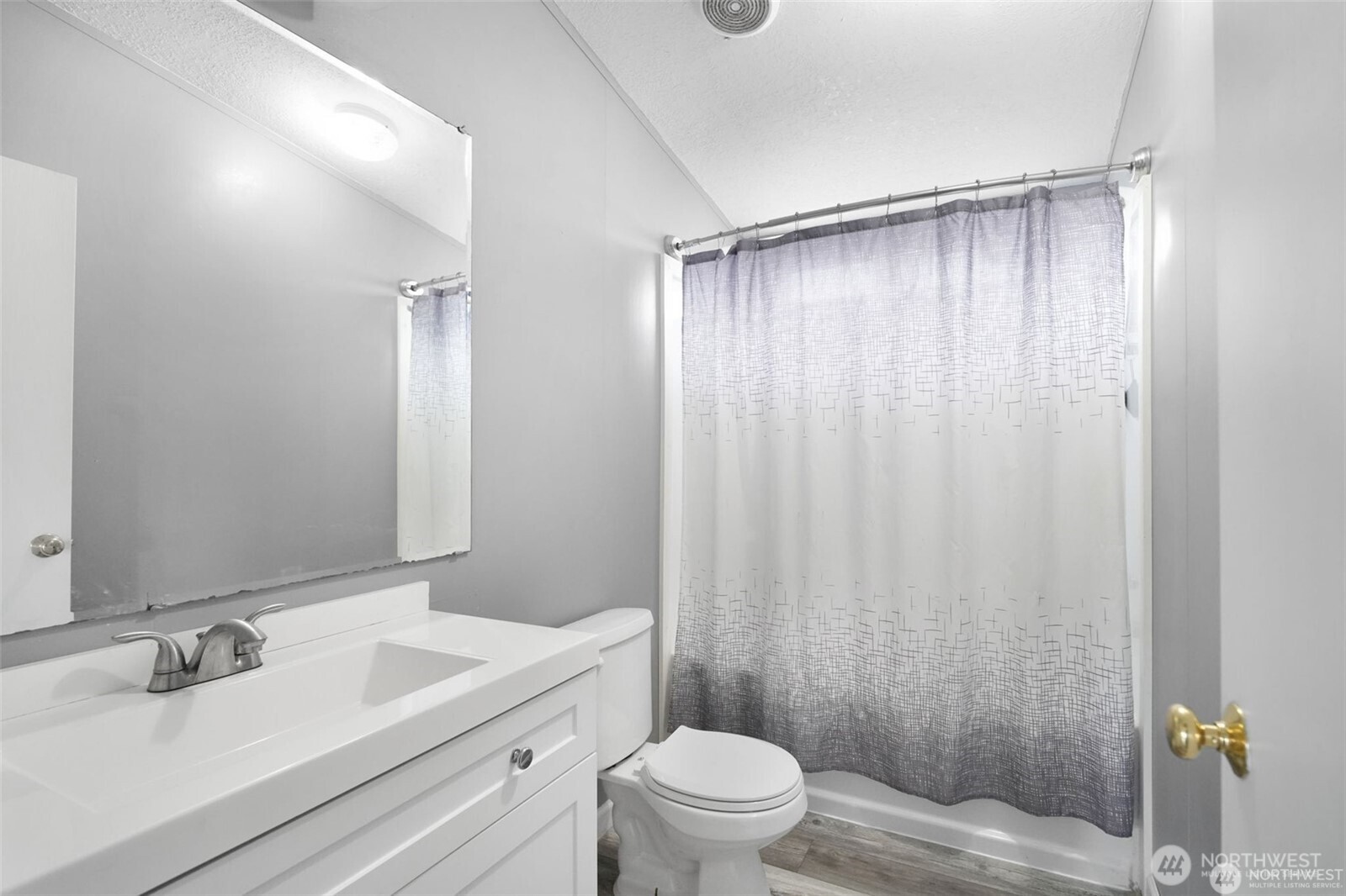 705 1st Avenue Southwest Castle Rock, WA 98611 - Photo 4 of 11 a bathroom with a sink a toilet a mirror and shower curtain