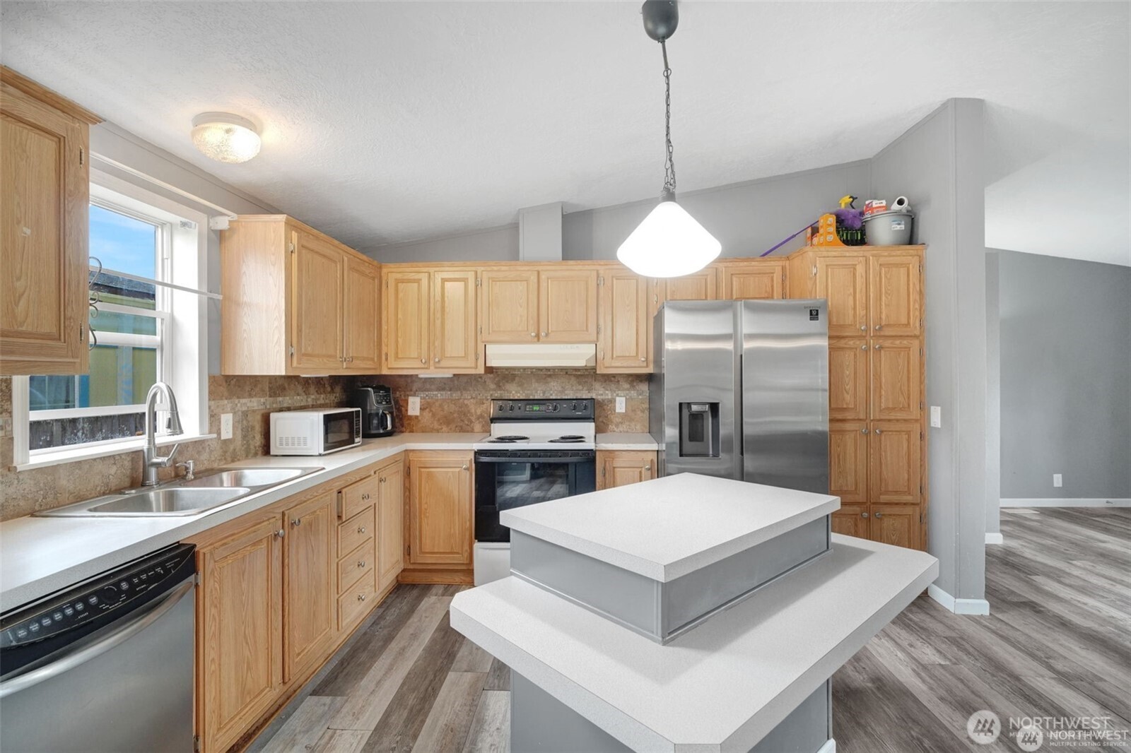 705 1st Avenue Southwest Castle Rock, WA 98611 - Photo 6 of 11 a kitchen with a refrigerator a sink and cabinets