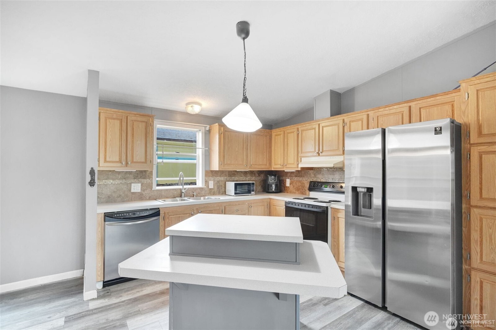 705 1st Avenue Southwest Castle Rock, WA 98611 - Photo 8 of 11 a kitchen with refrigerator a stove and white cabinets