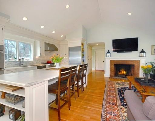 241 Barretts Mill Road Concord, MA 01742 - Photo 8 of 30 a living room with stainless steel appliances furniture a fireplace a flat screen tv and a kitchen view