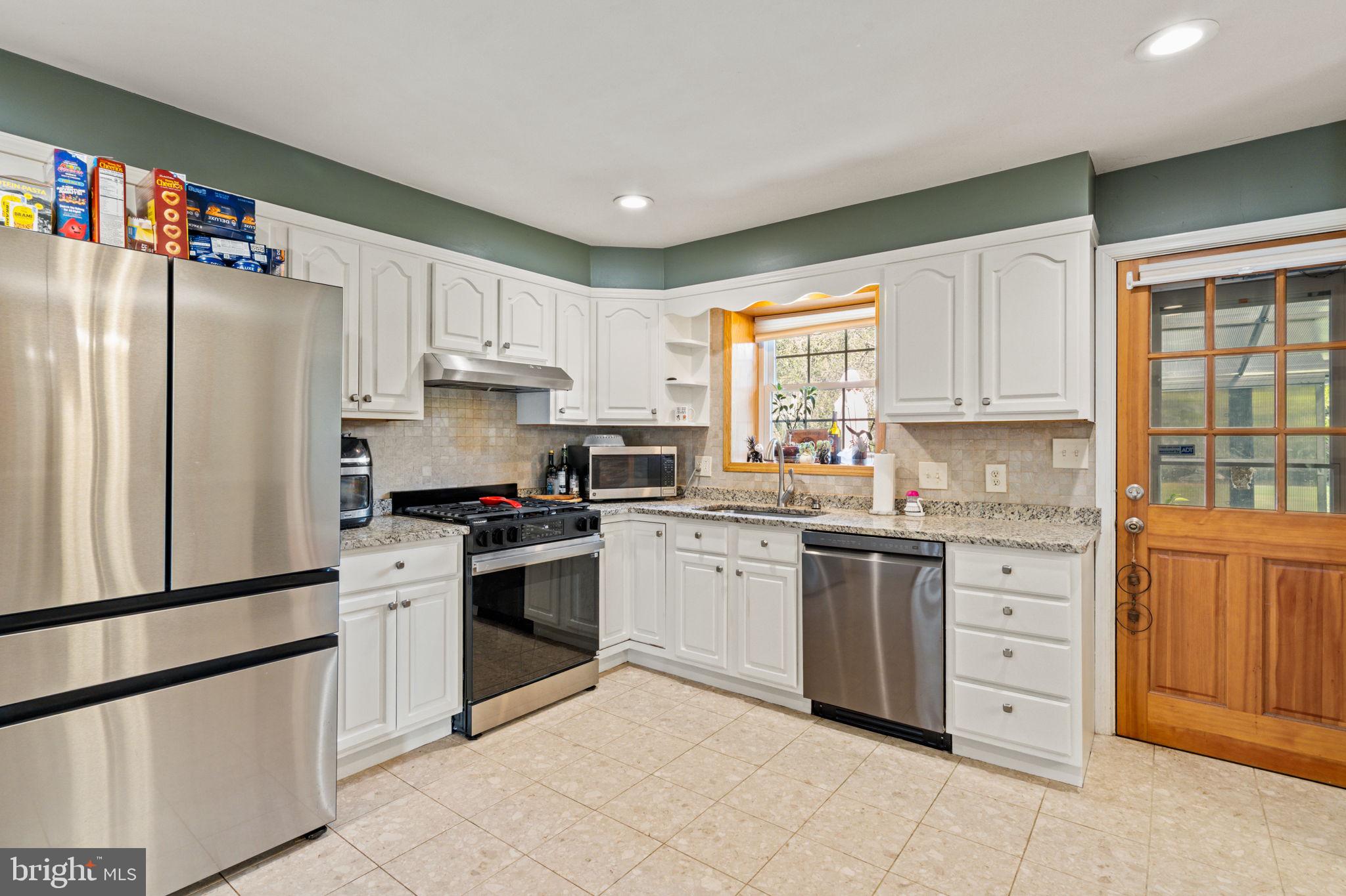 1505 Redwood Lane Wyncote, PA 19095 - Photo 11 of 51 a kitchen with granite countertop white cabinets and white stainless steel appliances