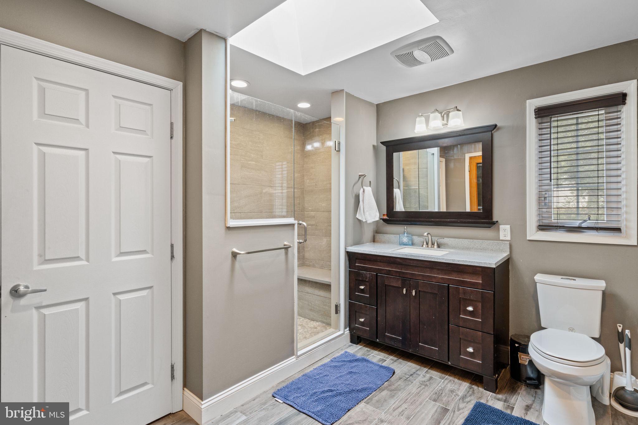 1505 Redwood Lane Wyncote, PA 19095 - Photo 29 of 51 a bathroom with a toilet a sink a vanity a mirror and a window