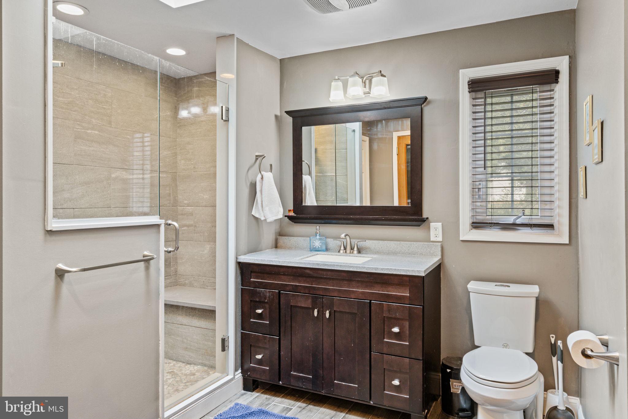 1505 Redwood Lane Wyncote, PA 19095 - Photo 32 of 51 a bathroom with a toilet a sink a mirror a window and vanity