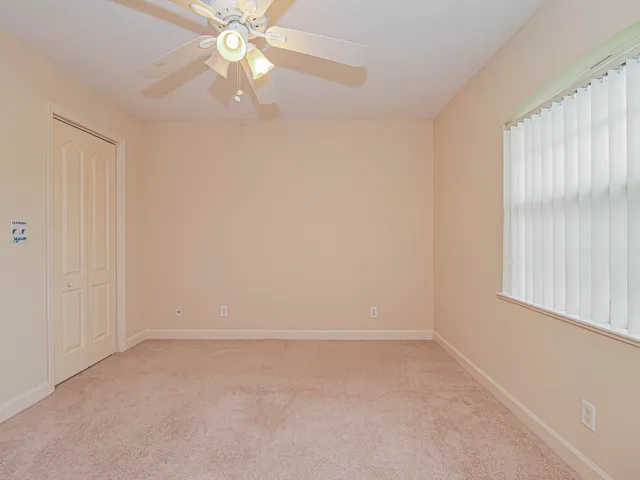 an empty room with a window and a fan