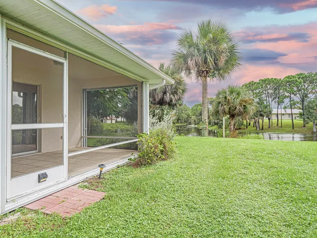 a view of a house with a big yard and large trees
