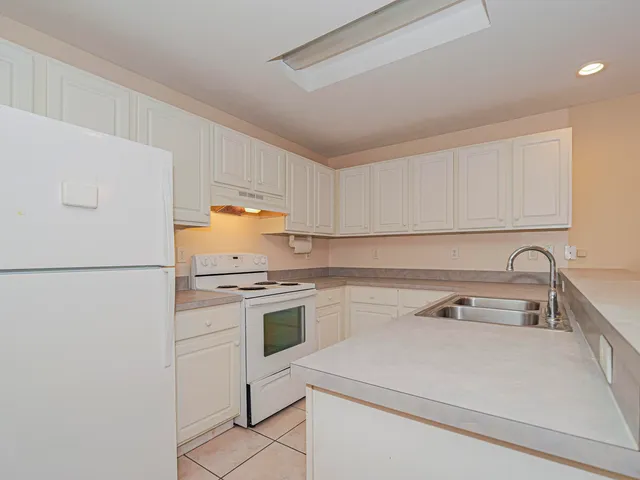 a kitchen with a sink a stove and cabinets