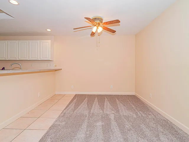 a view of a room with a ceiling fan and wooden floor