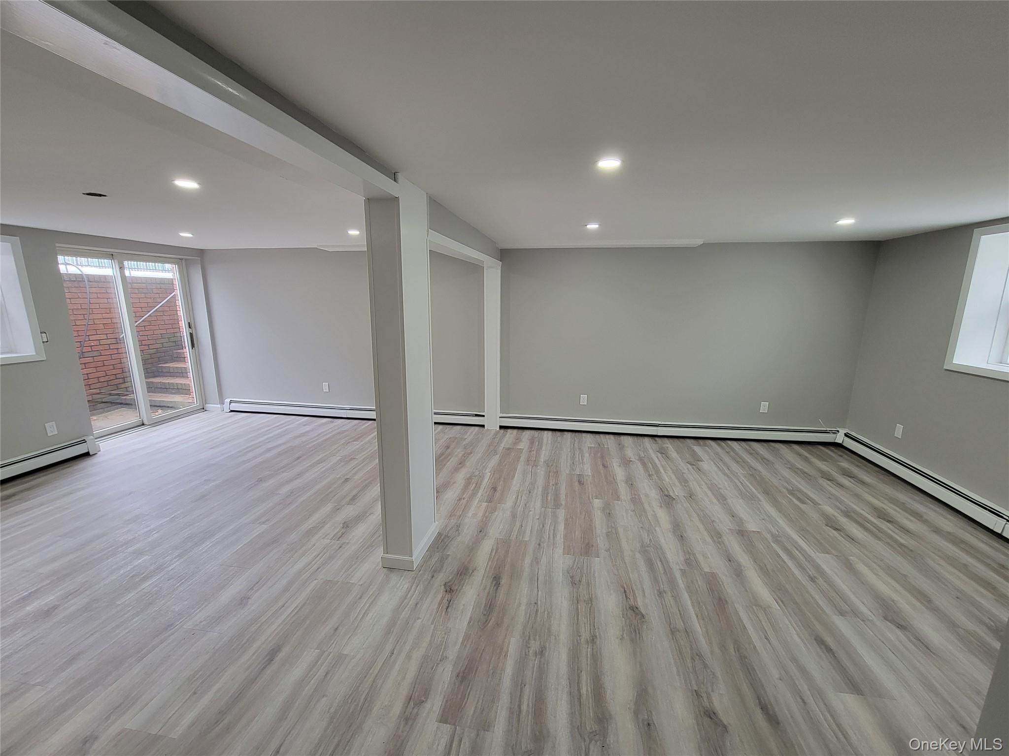 96 Hallock Landing Road Rocky Point, NY 11778 - Photo 12 of 13 an empty room with wooden floor and windows