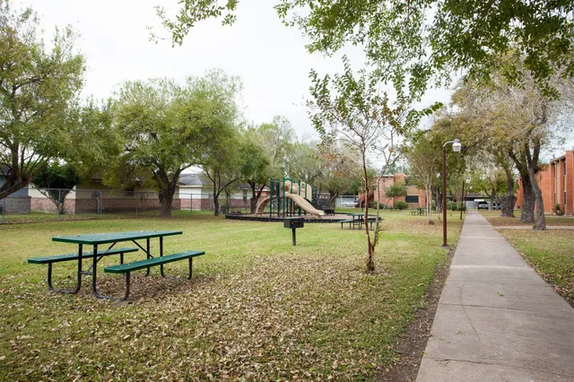 a view of park with benches and trees