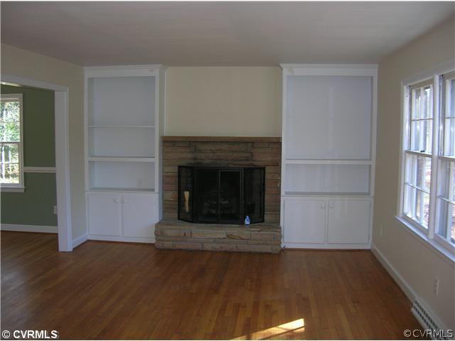 11451 Rolling Brook Road Chester, VA 23831 - Photo 4 of 11 an empty room with wooden floor fireplace and windows