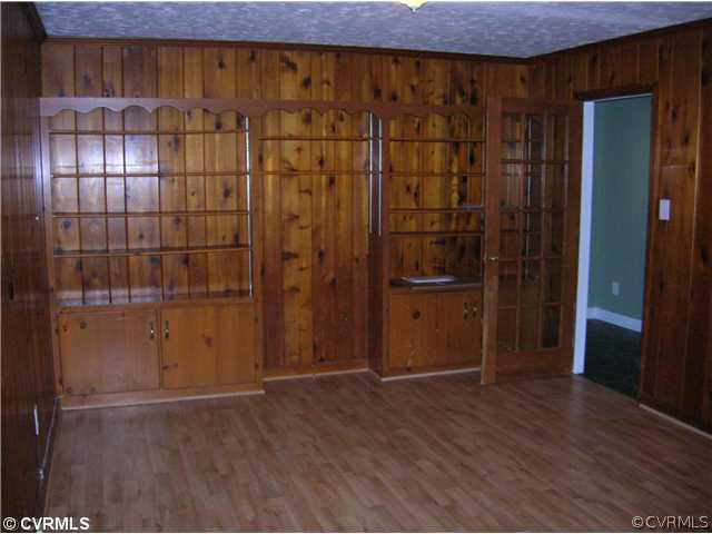 11451 Rolling Brook Road Chester, VA 23831 - Photo 5 of 11 an empty room with wooden floor and cabinet