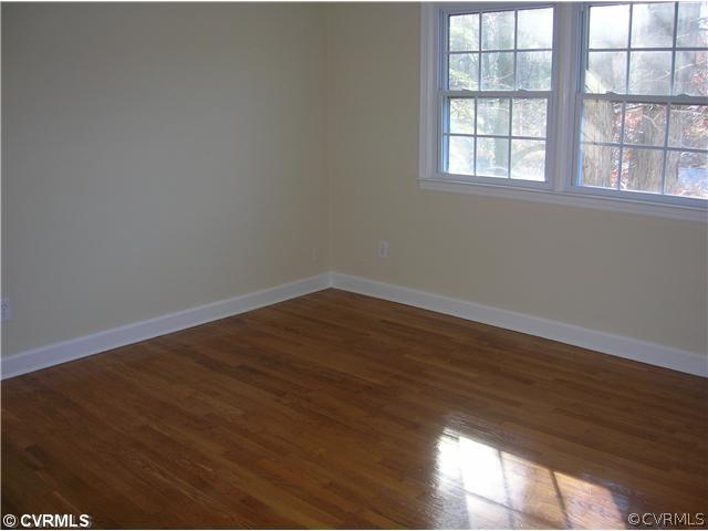11451 Rolling Brook Road Chester, VA 23831 - Photo 10 of 11 an empty room with wooden floor and windows