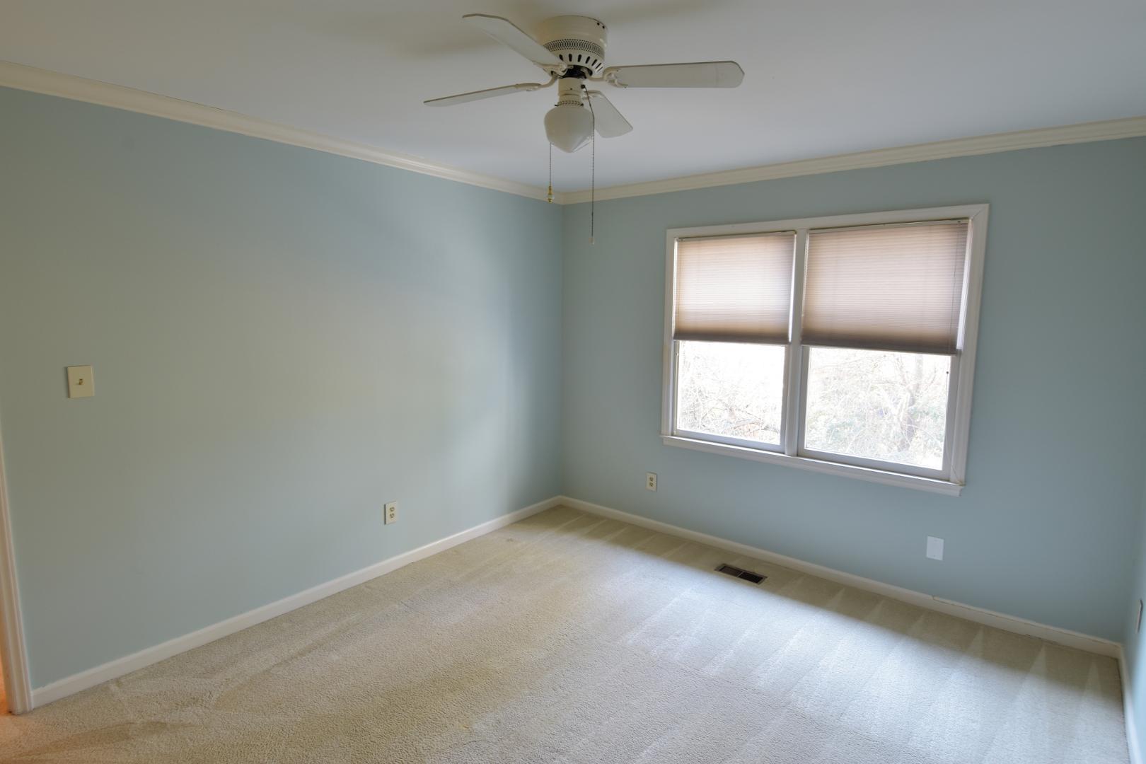 6403 Andsley Drive Raleigh, NC 27609 - Photo 15 of 18 an empty room with a window and a fan