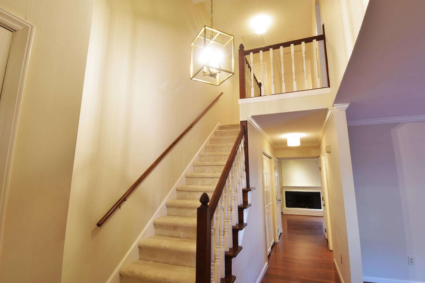 6403 Andsley Drive Raleigh, NC 27609 - Photo 2 of 18 a view of a hallway with wooden floor and staircase