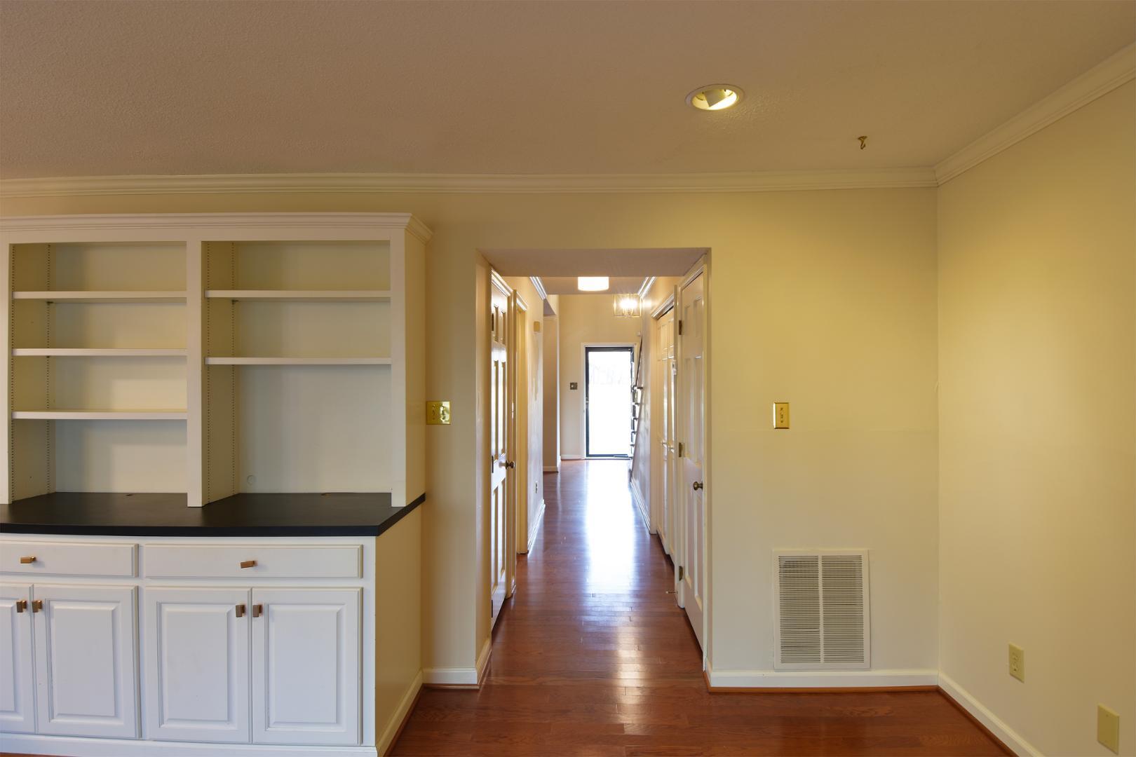 6403 Andsley Drive Raleigh, NC 27609 - Photo 7 of 18 a view of a hallway with wooden floor and cabinet