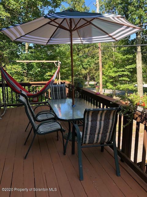 199 Eskra Road Lake Ariel, PA 18436 - Photo 25 of 36 a patio with wooden floor a yard a table and chairs