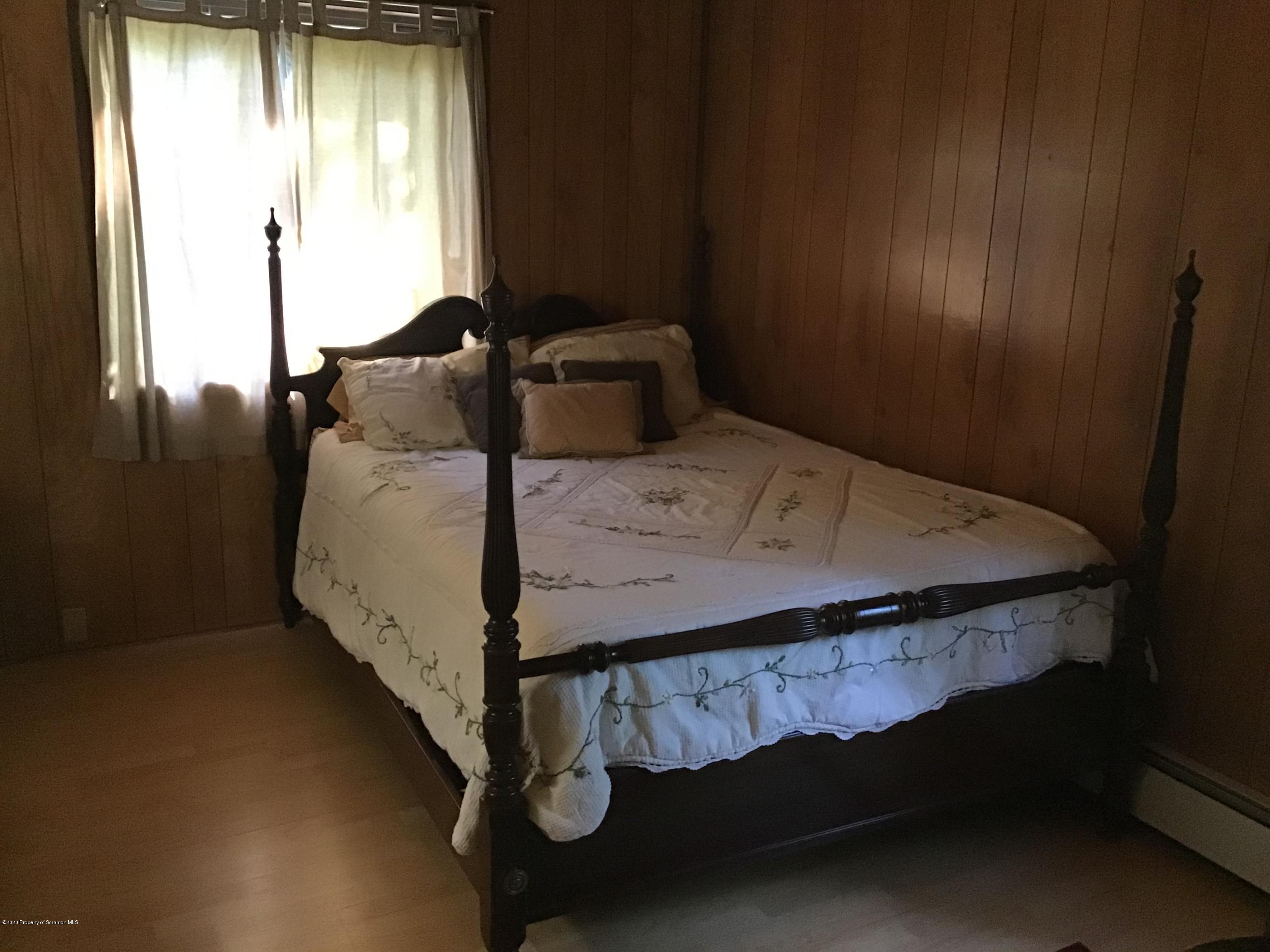 199 Eskra Road Lake Ariel, PA 18436 - Photo 8 of 36 a bed sitting in a bedroom next to a window