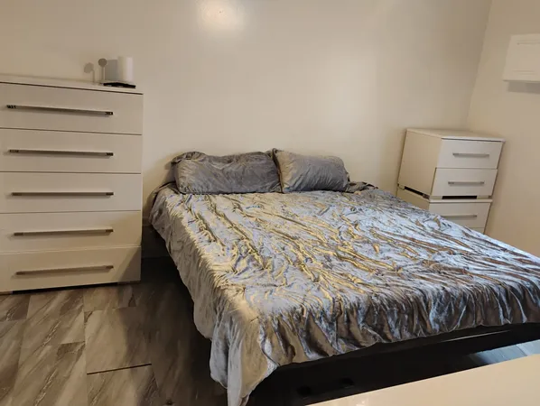 a bed sitting in a bedroom next to a window