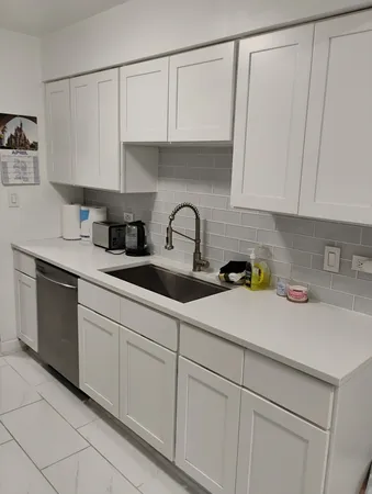 a kitchen with white cabinets and a sink