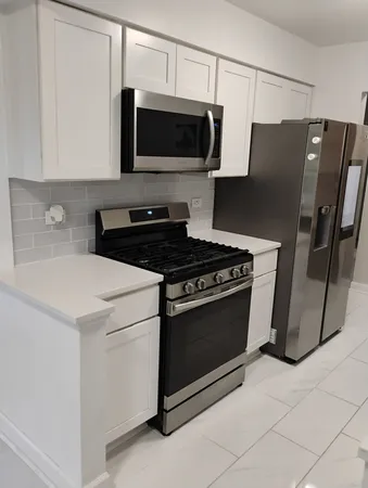 a kitchen with stainless steel appliances a stove microwave and refrigerator