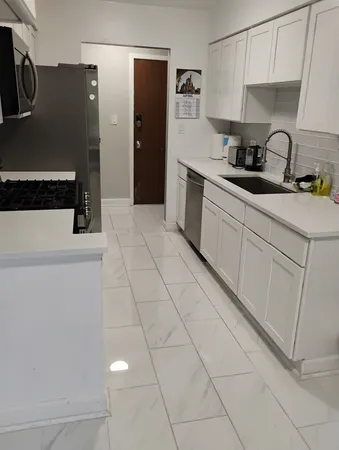a kitchen with stainless steel appliances a sink a stove a refrigerator a microwave and cabinets