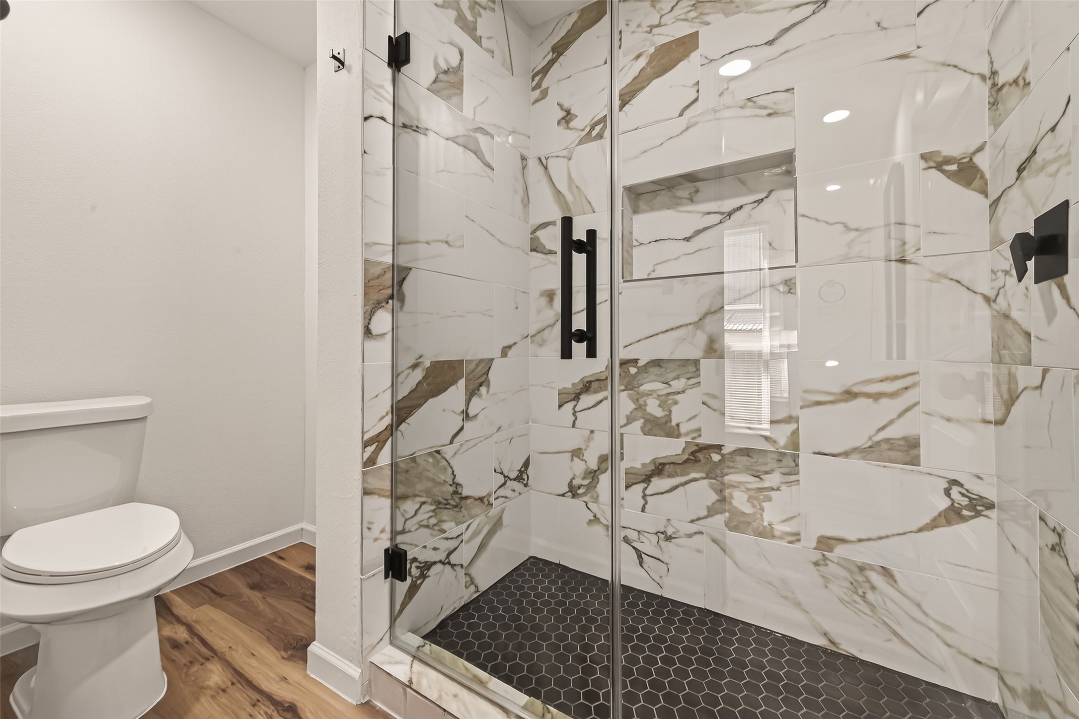 2915 Whispering Springs Drive Spring, TX 77373 - Photo 32 of 36 Luxurious walk-in shower with custom tile work, glass enclosure, and matte black fixtures.