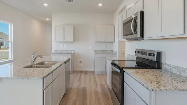 a kitchen with stainless steel appliances granite countertop a sink stove microwave and cabinets