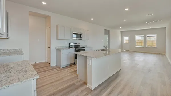 a kitchen with cabinets and wooden floor