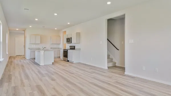 a view of a kitchen with wooden floor and electronic appliances