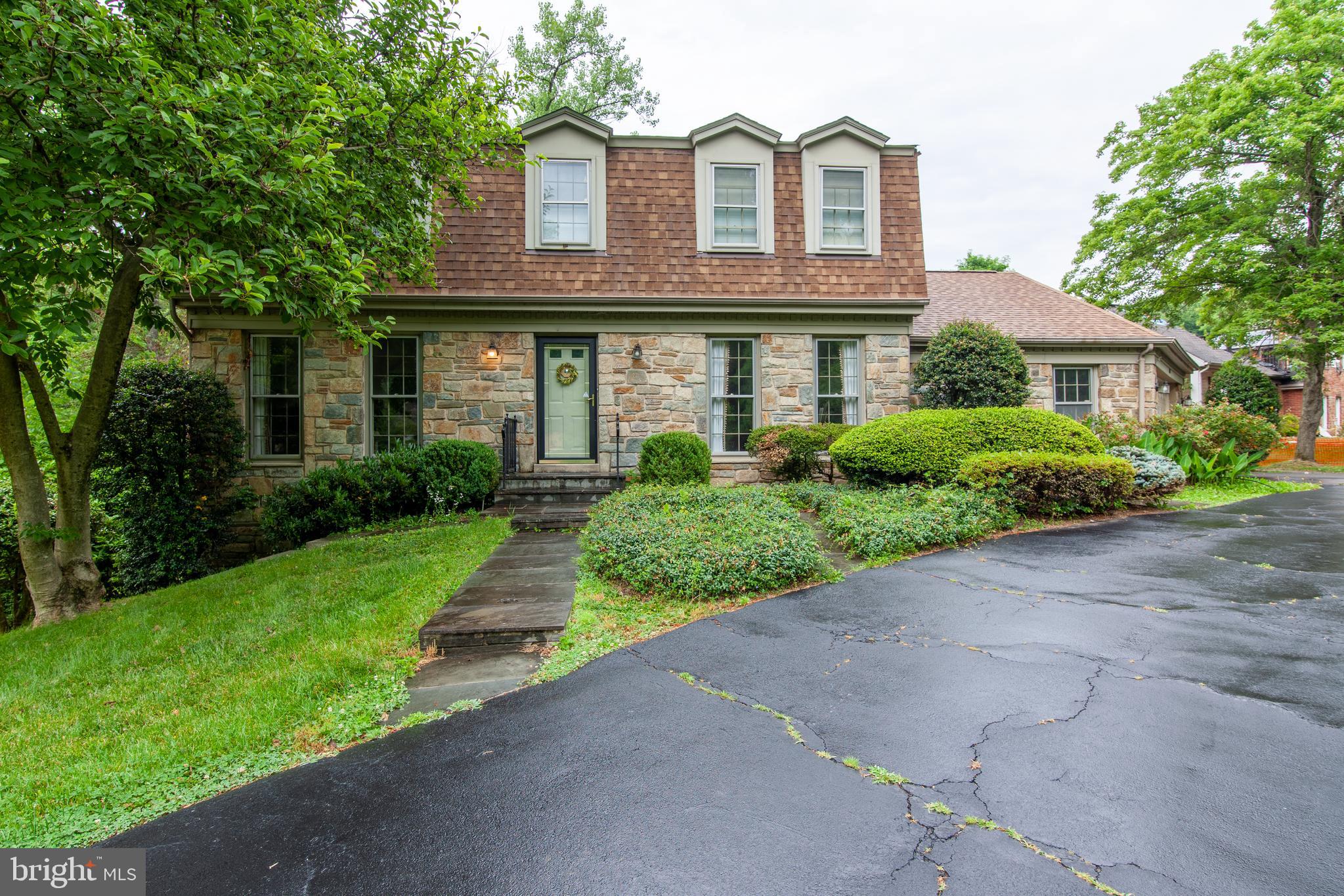 6034 Chesterbrook Road, Unit B McLean, VA 22101 - Photo 1 of 19 a front view of a house with a garden and trees