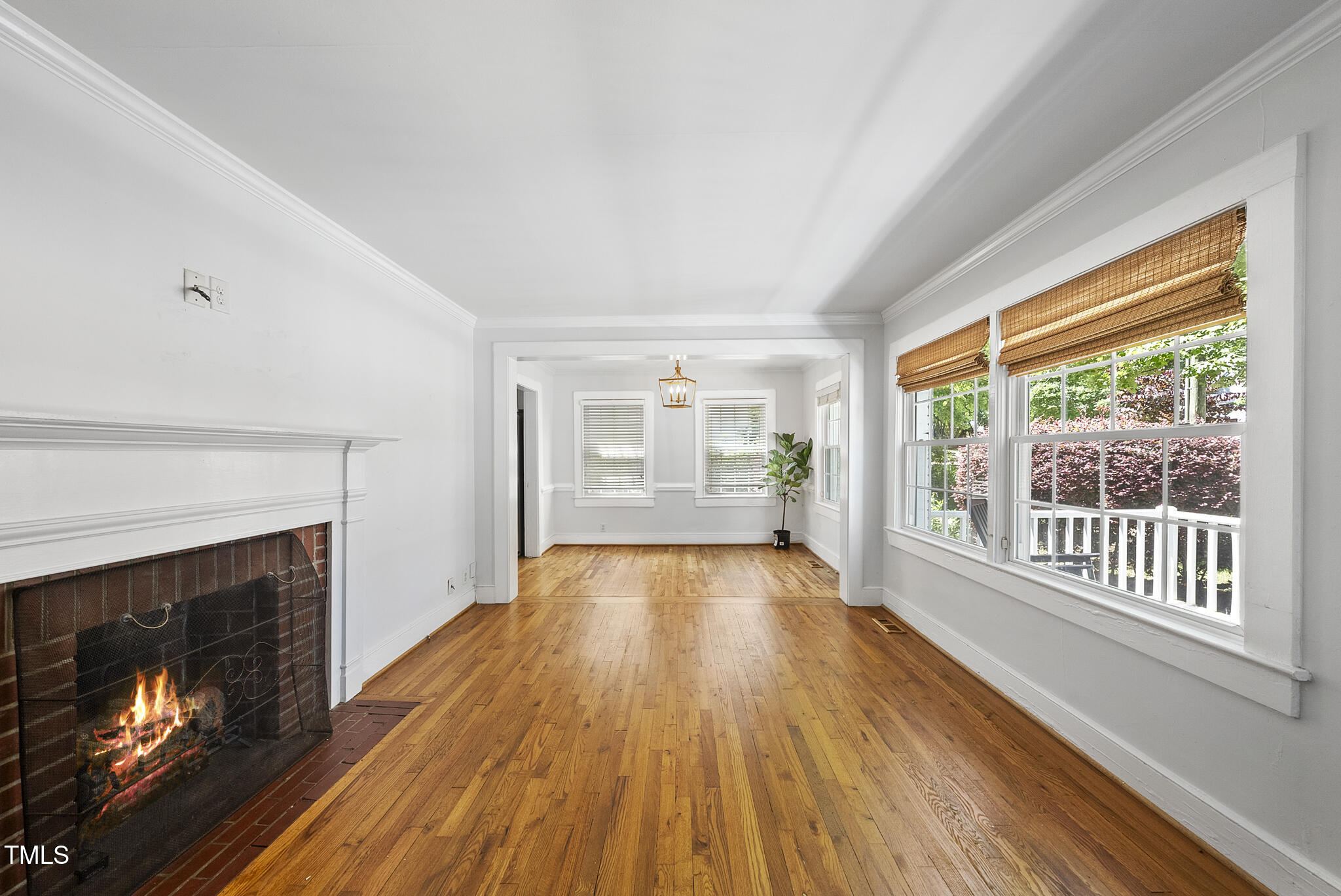 1812 Hilton Street Raleigh, NC 27608 - Photo 4 of 31 a view of an empty room with wooden floor fireplace and a window