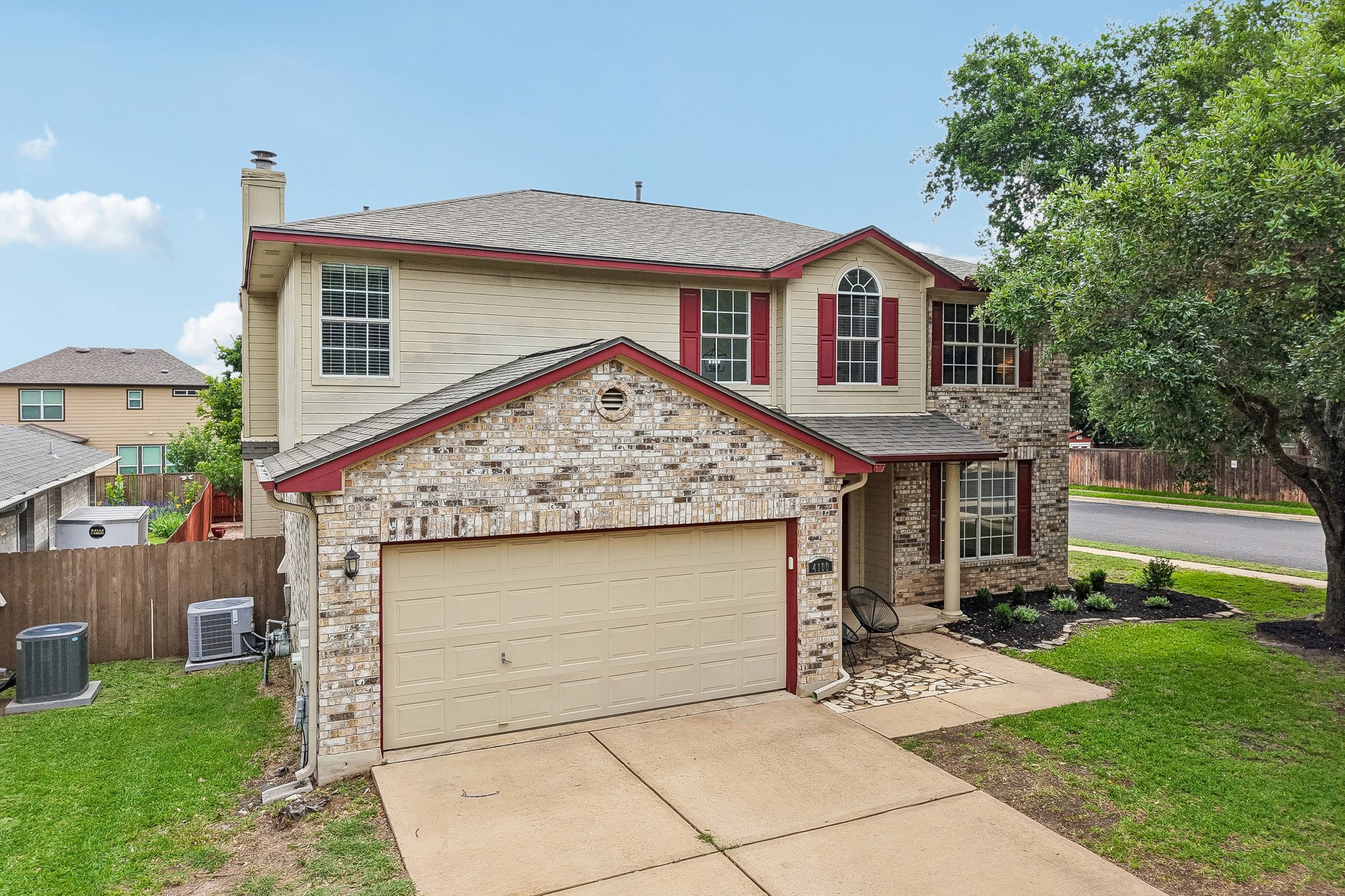 4100 Mocha Trail Austin, TX 78728 - Photo 29 of 33 A classic brick and siding two-story home, with an attached garage and a mature shade tree.