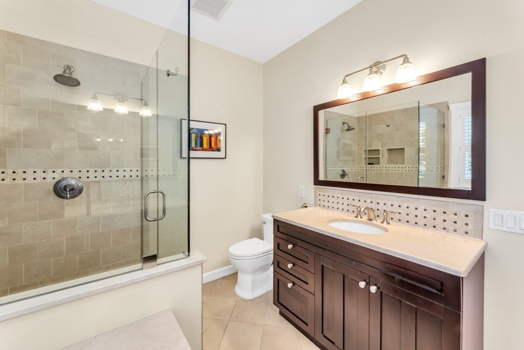 53 B Burroughs Street Boston, MA 02130 - Photo 19 of 41 a bathroom with a sink vanity mirror and toilet