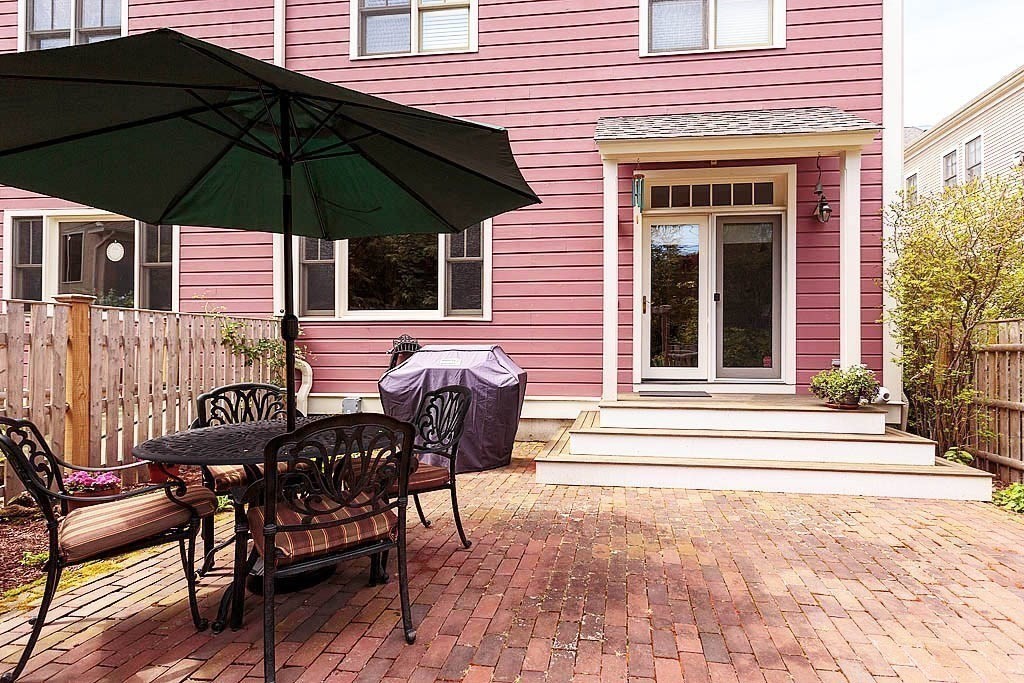 53 B Burroughs Street Boston, MA 02130 - Photo 35 of 41 a patio with a table and chairs under an umbrella