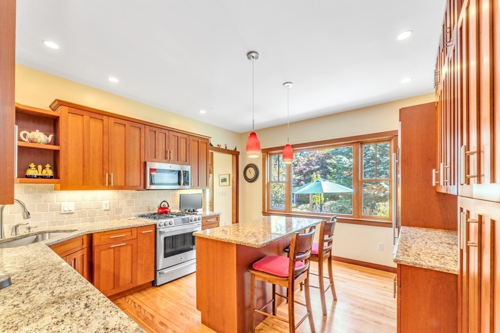 53 B Burroughs Street Boston, MA 02130 - Photo 9 of 41 a kitchen with granite countertop a stove a sink dishwasher and a refrigerator with wooden floor